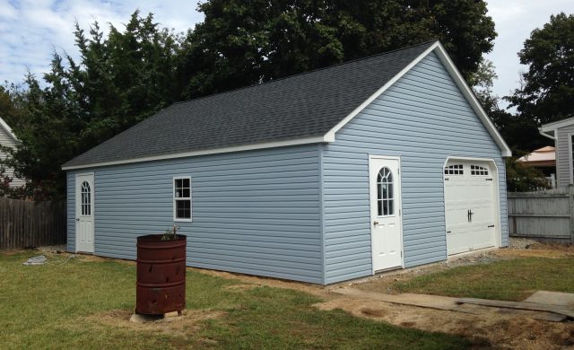 large blue one car garage and storage shed
